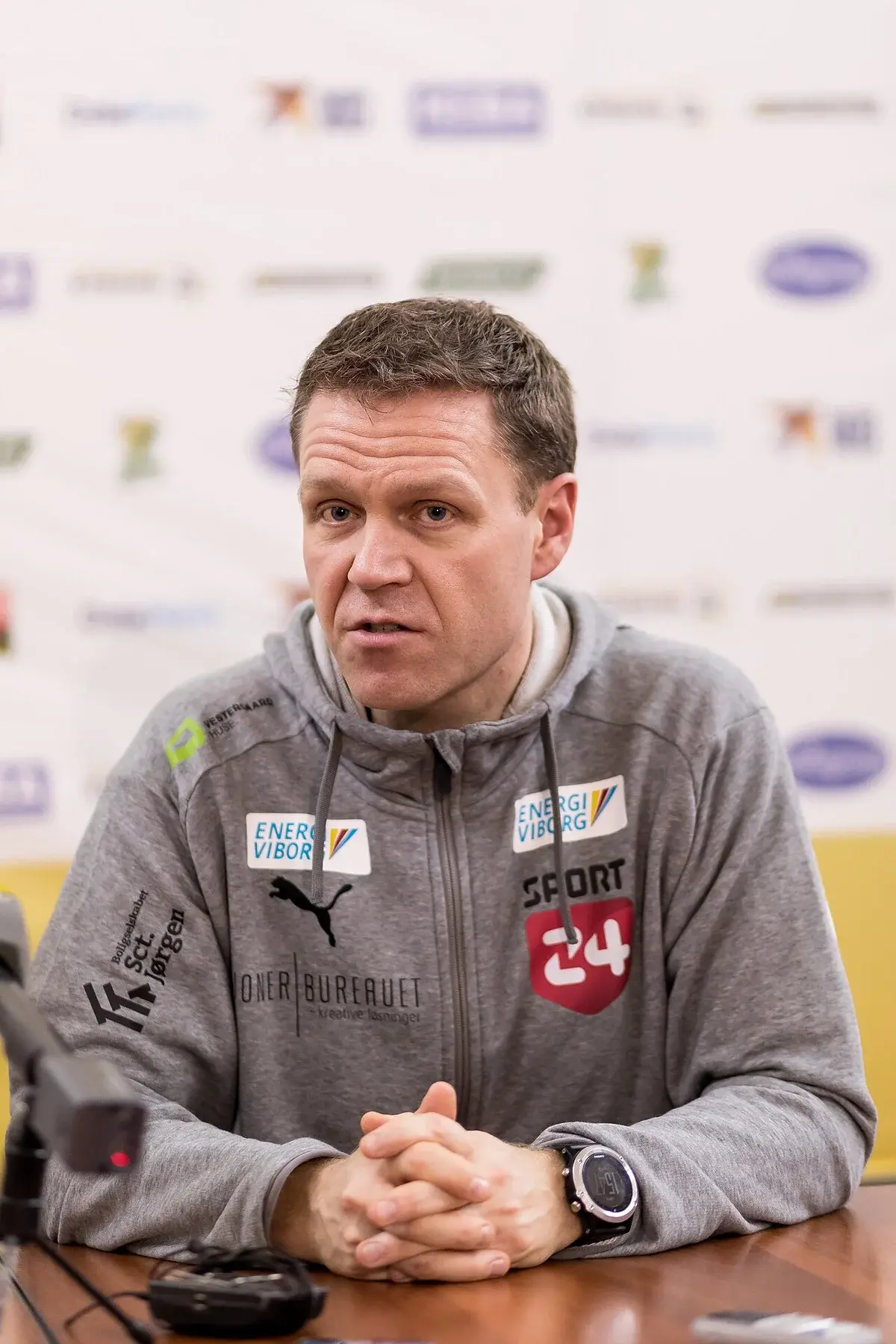 Portrait of handball coach Jakob Vestergaard seated at a table during a Viborg HK event.