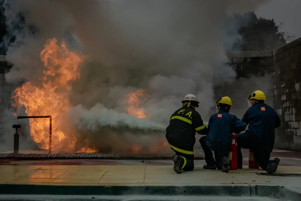 Firefighters training to put out a controlled fire outdoors.