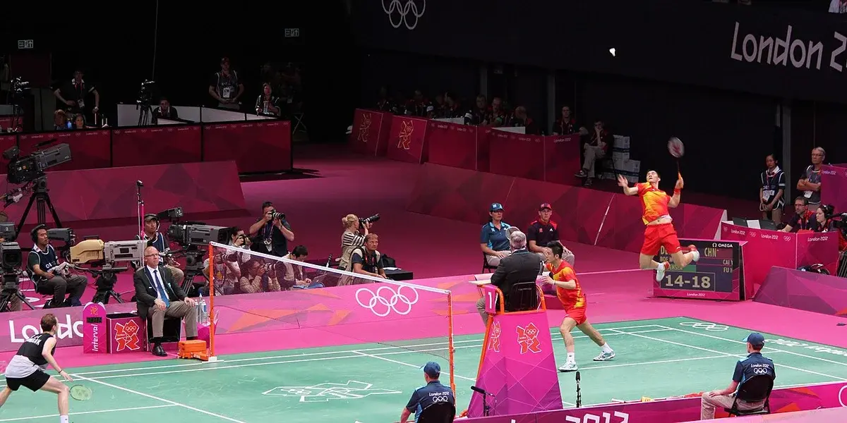 Badminton doubles match in a large arena during an international tournament.