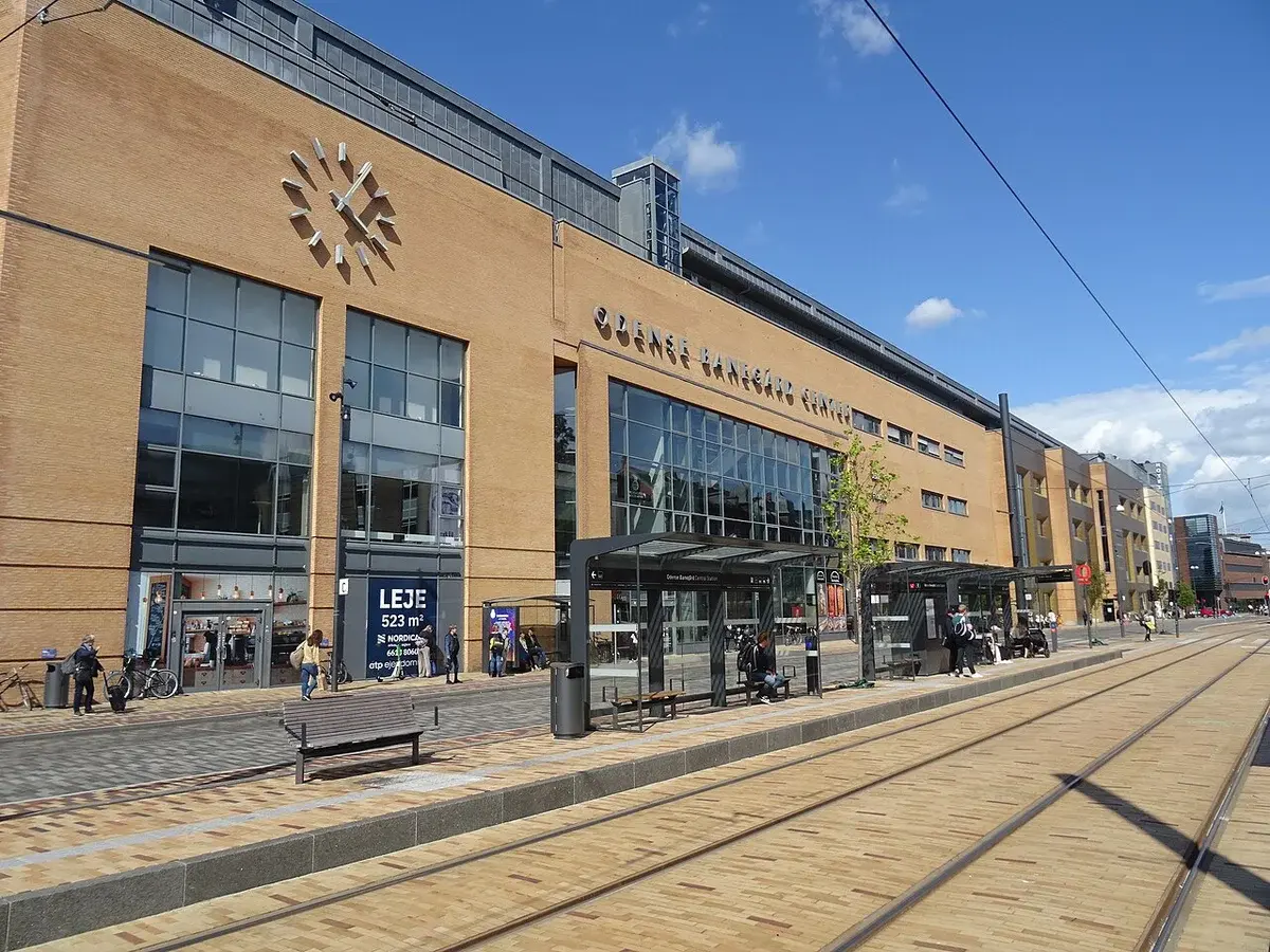 Odense Banegård Center with tram tracks and a light rail stop in front.