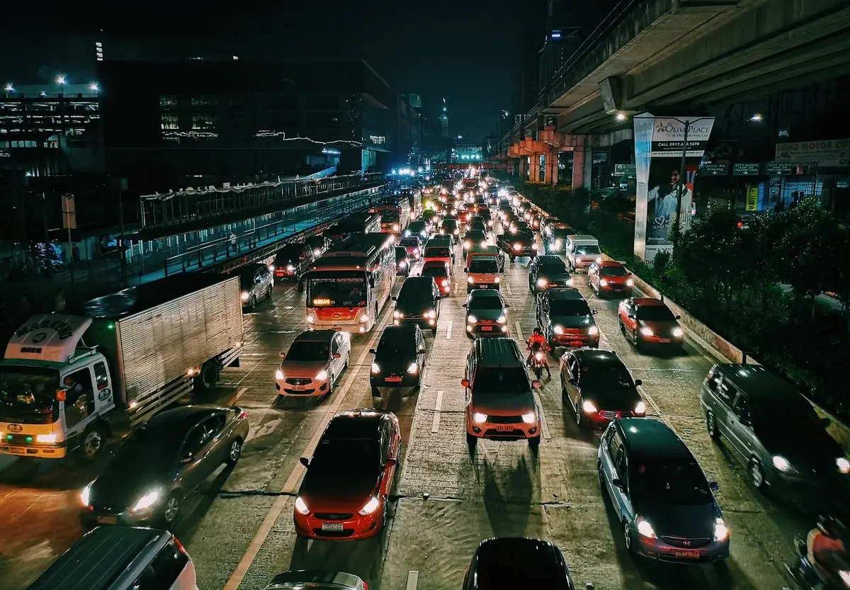 Heavy traffic on a city highway at night with many cars and buses.
