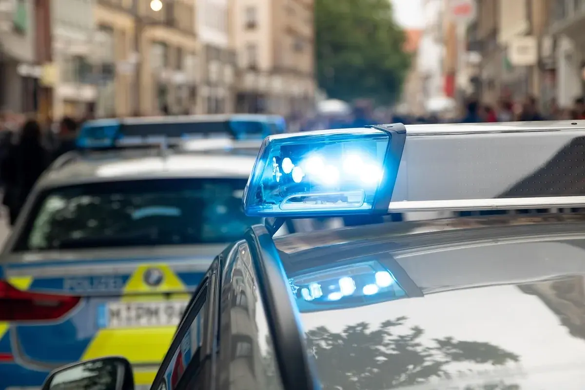 Police cars with blue lights flashing on a city street